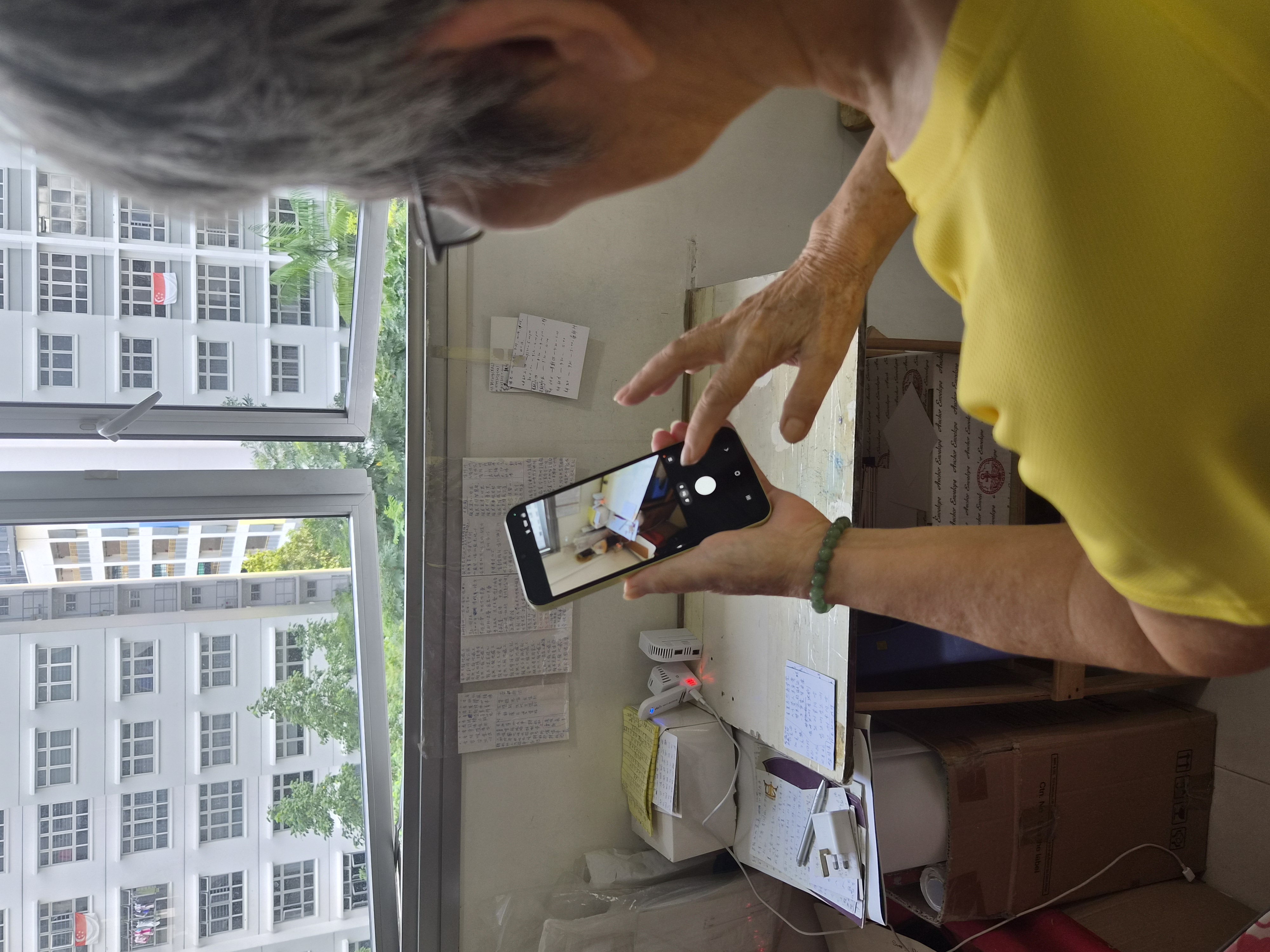 A participant taking a photo of her StayCool sensor during a home visit.